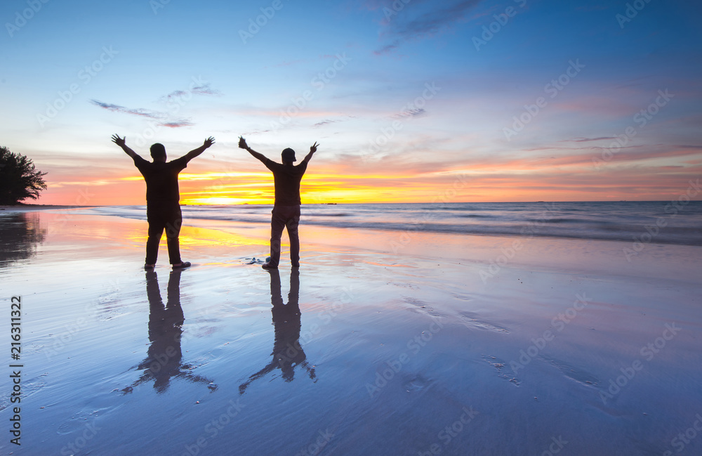 Fototapeta premium two men at the beach during beautiful sunset. 
