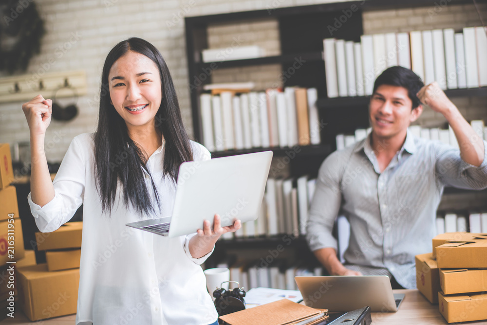 Happy young Asian man and woman at office of their business online shopping. Happy young Asian man and woman at office of their business online shopping.