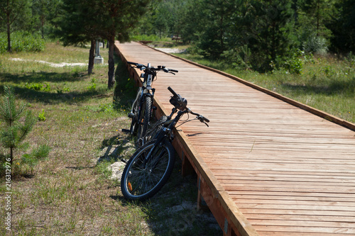 Two bikes at the wooden path.