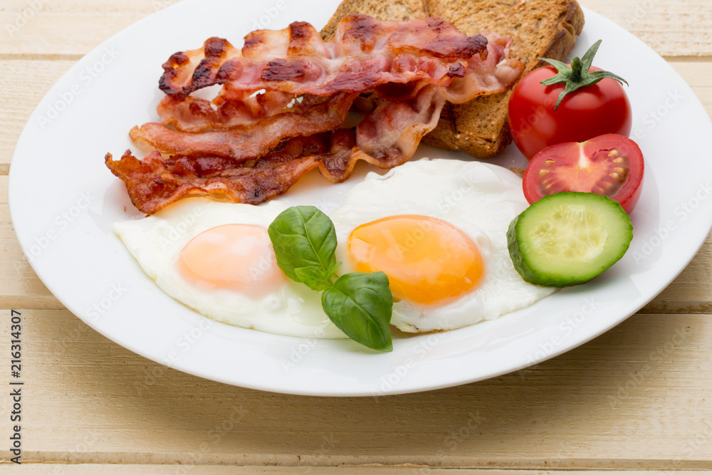 Fried eggs with bacon on the wooden table. Fried eggs with bacon on the wooden table.