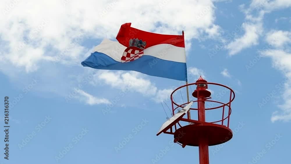 Lighthouse, light beacon pole with flying Croatian flag in daylight, slow motion 4x, close up shot Lighthouse, light beacon pole with flying Croatian flag in daylight, slow motion 4x, close up shot