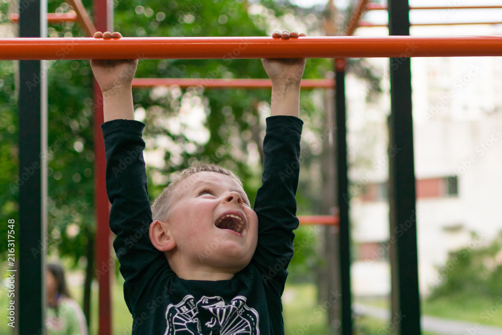 A little boy on the bar. Physical activity and development of the child. A little boy on the bar. Physical activity and development of the child.