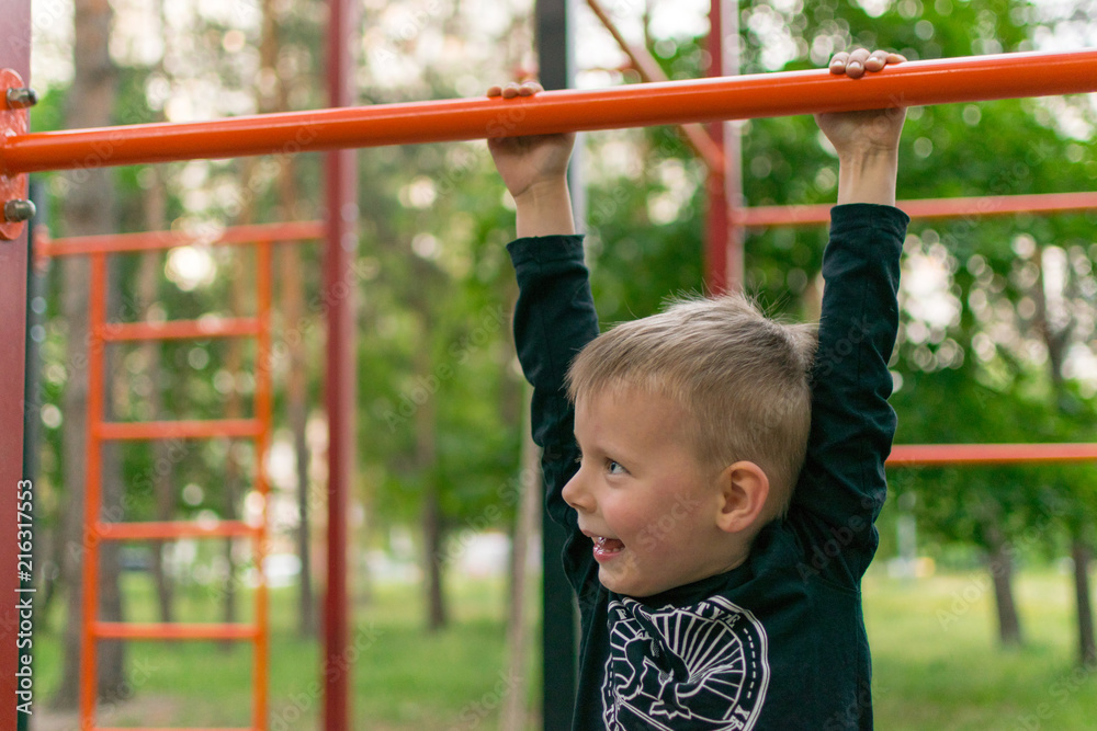 A little boy on the bar. Physical activity and development of the child. A little boy on the bar. Physical activity and development of the child.