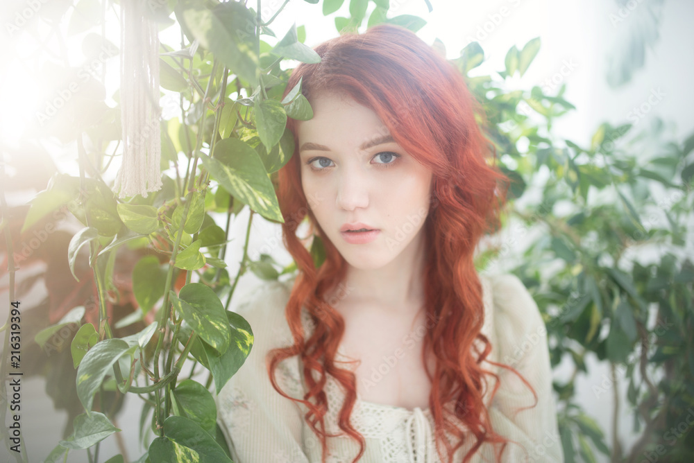 Tender portrait of a young beautiful dreamy redhead woman among foliage. Tender portrait of a young beautiful dreamy redhead woman among foliage.