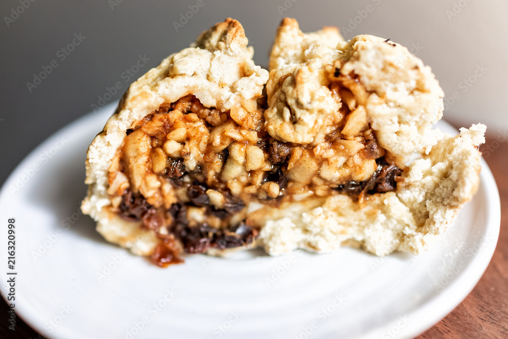 Closeup of large slice piece of apple pie cake, fruit filling and healthy golden crust with cinnamon on white plate, raisins Closeup of large slice piece of apple pie cake, fruit filling and healthy golden crust with cinnamon on white plate, raisins