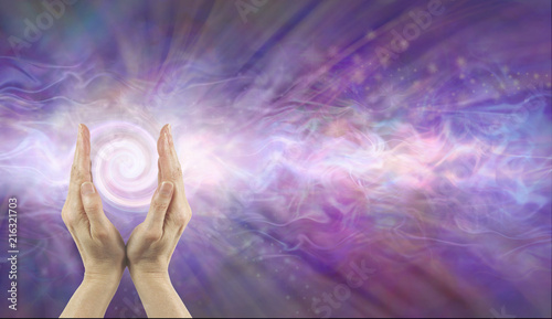 Fototapeta Naklejka Na Ścianę i Meble -  Channeling Vortex healing energy  - female hands facing upwards with a white spiralling vortex energy formation and pink blue purple misty ethereal energy field background with copy space 
