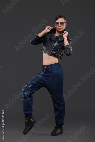 Luxury Fashion model, a beautiful woman posing in studio on gray background with glasses from the sun. © satyrenko