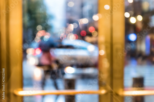 Grand central terminal entrance from Lexington Avenue in New York City NYC, rainy day or evening, looking outside through door window blurred abstract background bokeh, cars, traffic photo