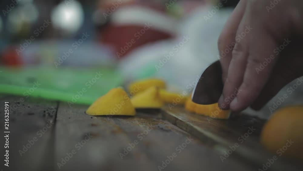 Cutting Lemon into Slices with a Sharp Knife on a Wooden Board Outside Cutting Lemon into Slices with a Sharp Knife on a Wooden Board Outside