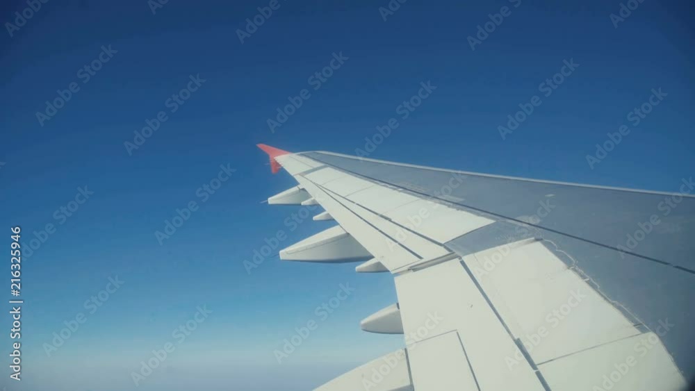 View through the airplane's window, wing, clouds, blue sky nature View through the airplane's window, wing, clouds, blue sky nature