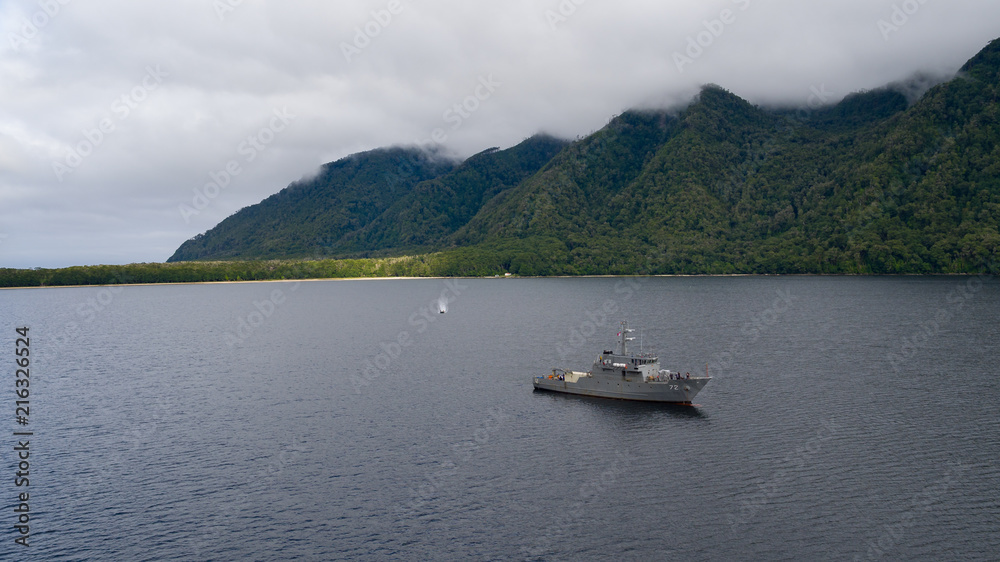 Ship in mooring maneuver, in the Slight bay in southern Chile. Near the Gulf of Penas