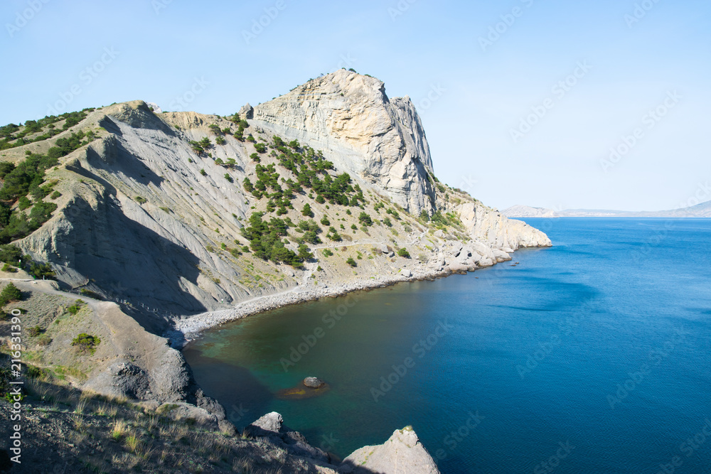 Beautiful rock off the coast of the sea. Turquoise water, blue sky, incredible landscape.
