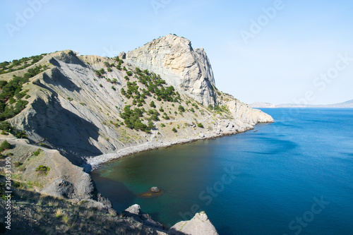 Beautiful rock off the coast of the sea. Turquoise water, blue sky, incredible landscape.