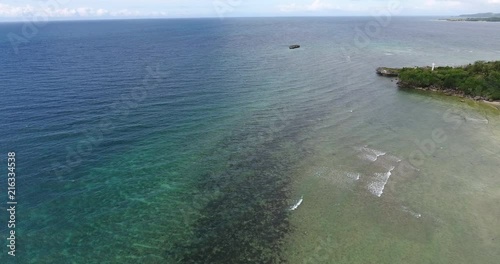 4K cinematic aerial footage tilting down revealing the sweel of waves crashing on the beach at Tablas Island in the Philippines. photo