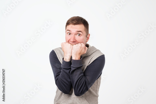 European man covering his mouth with both hands, looking shocked. photo