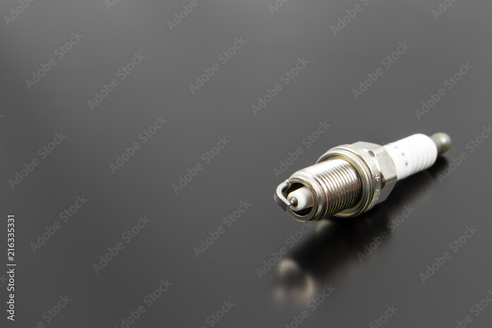 New spark plug isolated on a black gray background New spark plug isolated on a black gray background