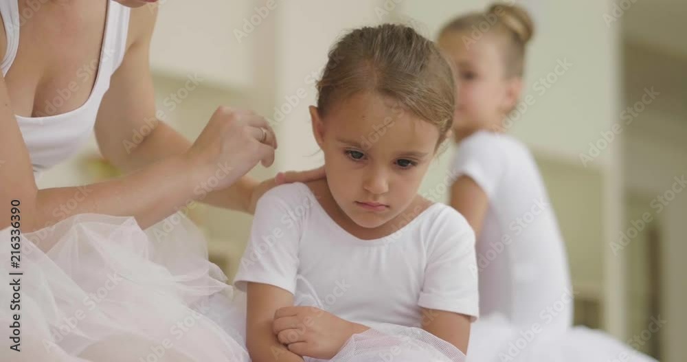 A teacher of classical dance teaches some steps to her young students who want to learn how to dance. Concept of: ambition, education, teaching and love for the dance