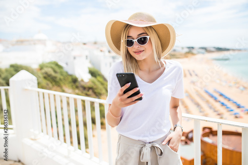 Single happy girl checking a smart phone sitting in a terrace