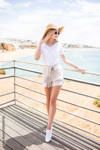 Portrait of young pretty woman with hat and sunglasses on the top near beach © F8  \ Suport Ukraine