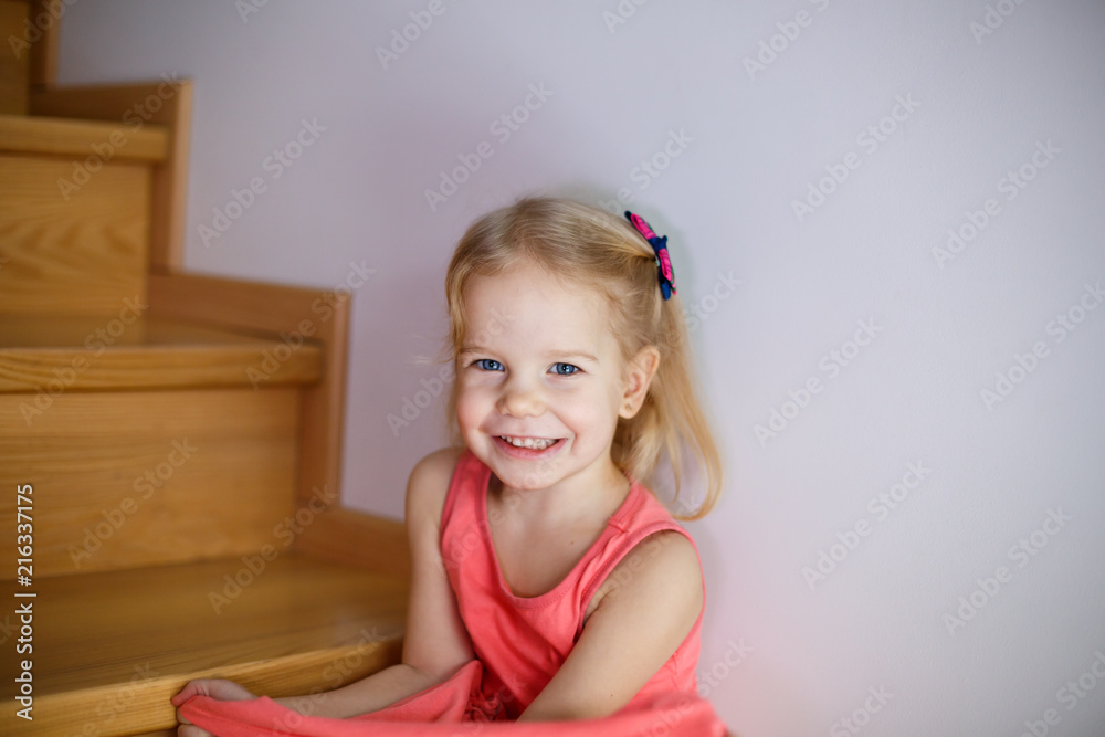 Portrait of little cute girl smiling on stairs in cozy room Portrait of little cute girl smiling on stairs in cozy room