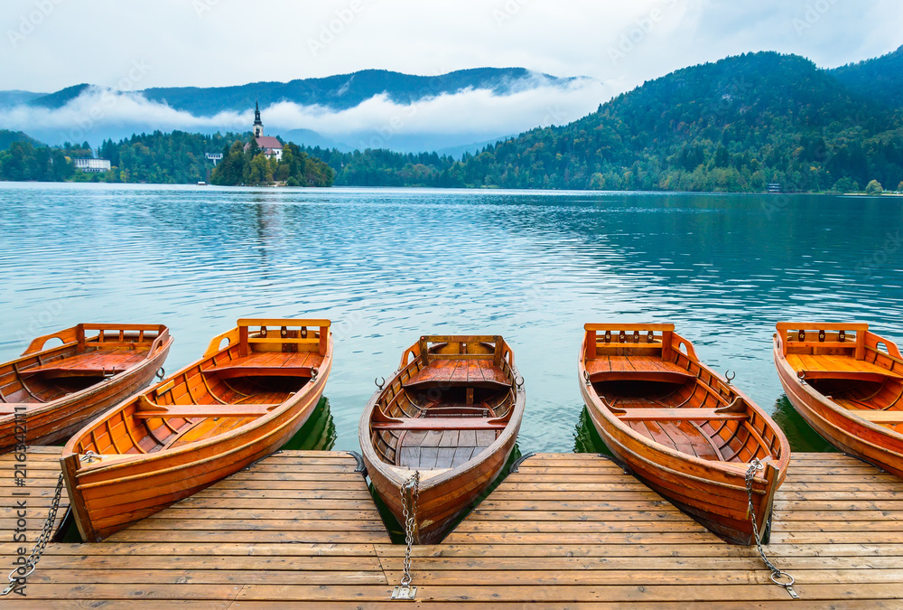 Boats on Bled Lake in Slovenia. Mountain lake with small island, and church.