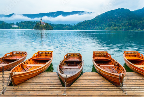 Boats on Bled Lake in Slovenia. Mountain lake with small island  and church.