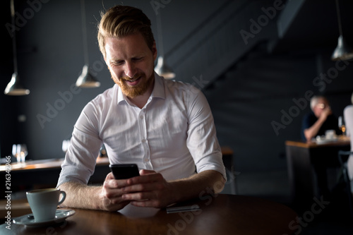 A handsome young businessman spends his time in a city bar.