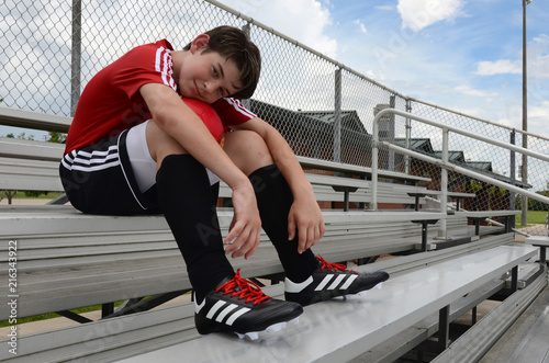 Male child soccer player chilling out before game