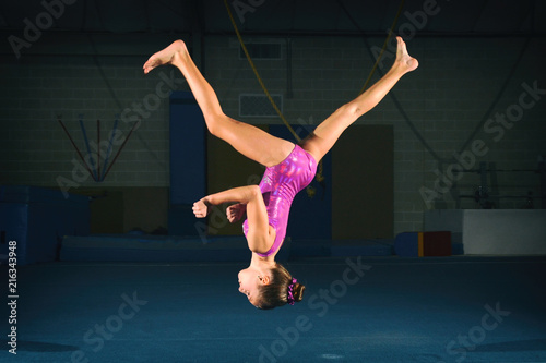 Female child gymnast performing an aerial