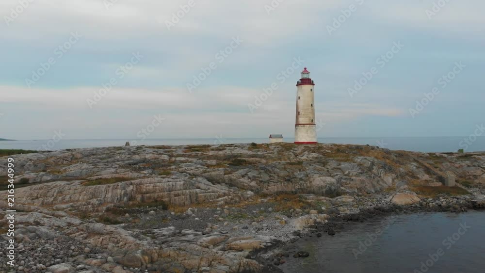 Aerial drone shot wide orbit around of Tiny Torungen Lighthouse in Norway where it stands on its rocky peninsula overlooking the ocean Aerial drone shot wide orbit around of Tiny Torungen Lighthouse in Norway where it stands on its rocky peninsula overlooking the ocean