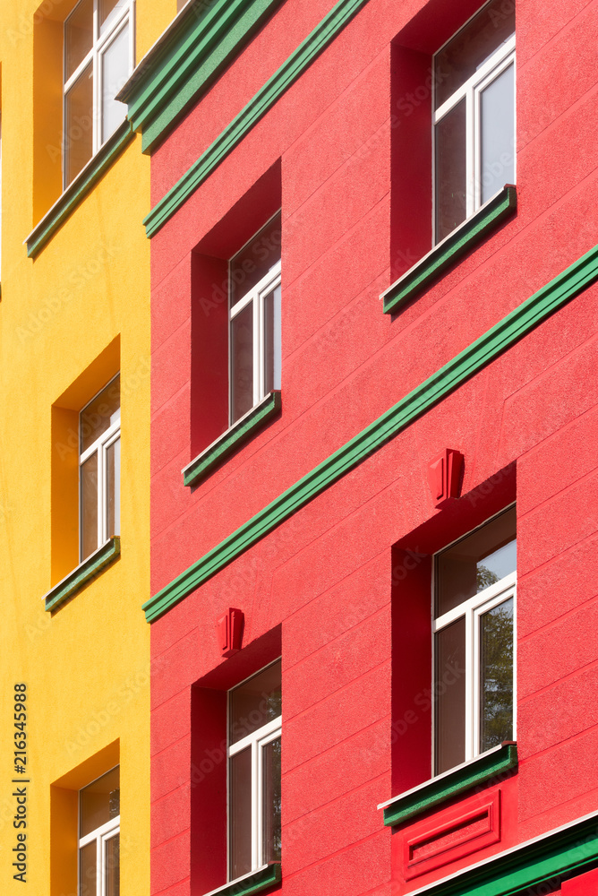 yellow-red building with green cornice, close-up shot, building element
