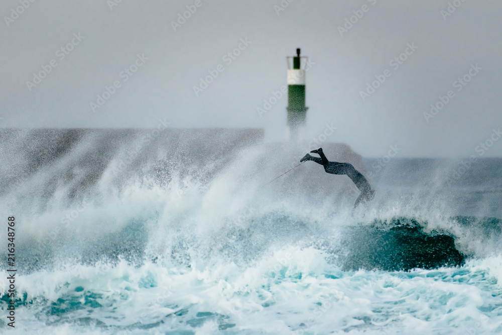 Surfer jumping over a wave during a windy day
