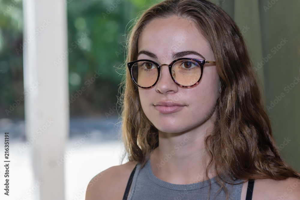 Young woman with serious face wearing glasses portrait with room for copy text