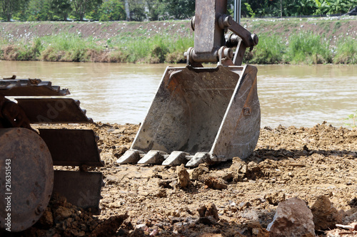 excavator or backhoe bucket on the soil floor. also called a scoop to qualify shallower designs of tools. photo