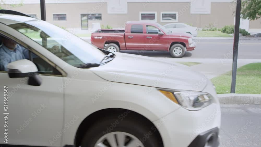 Man pulls up to woman waiting for him to pick her up and take her to a destination she picked for the Uber driver. Man pulls up to woman waiting for him to pick her up and take her to a destination she picked for the Uber driver.