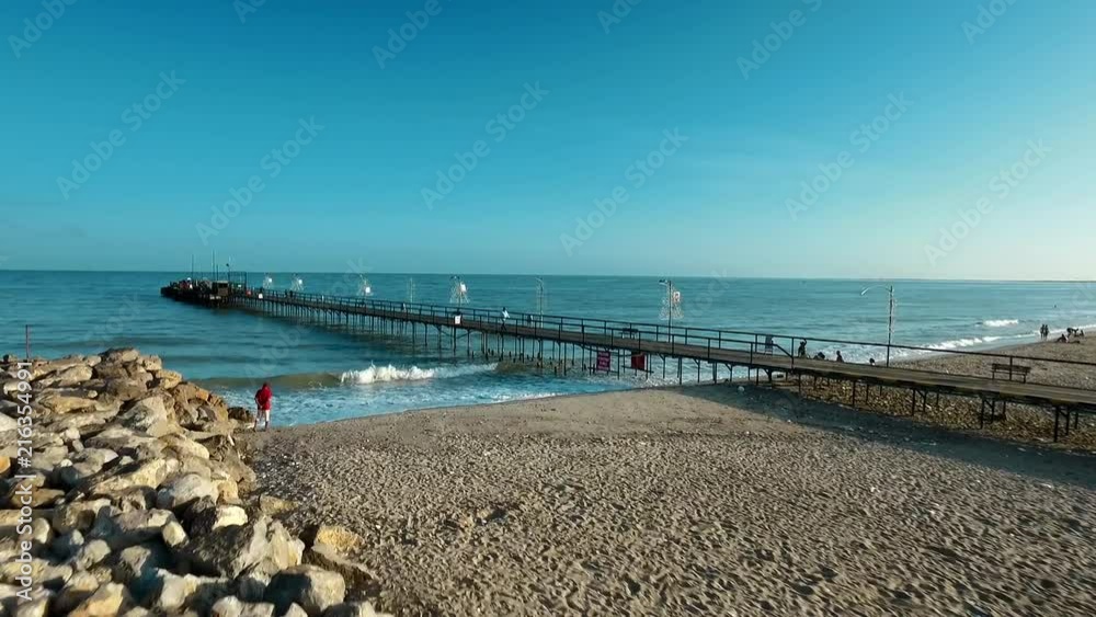 Aerial: flying near along dock in an extensive beach in a sunny afternoon 2 Aerial: flying near along dock in an extensive beach in a sunny afternoon 2