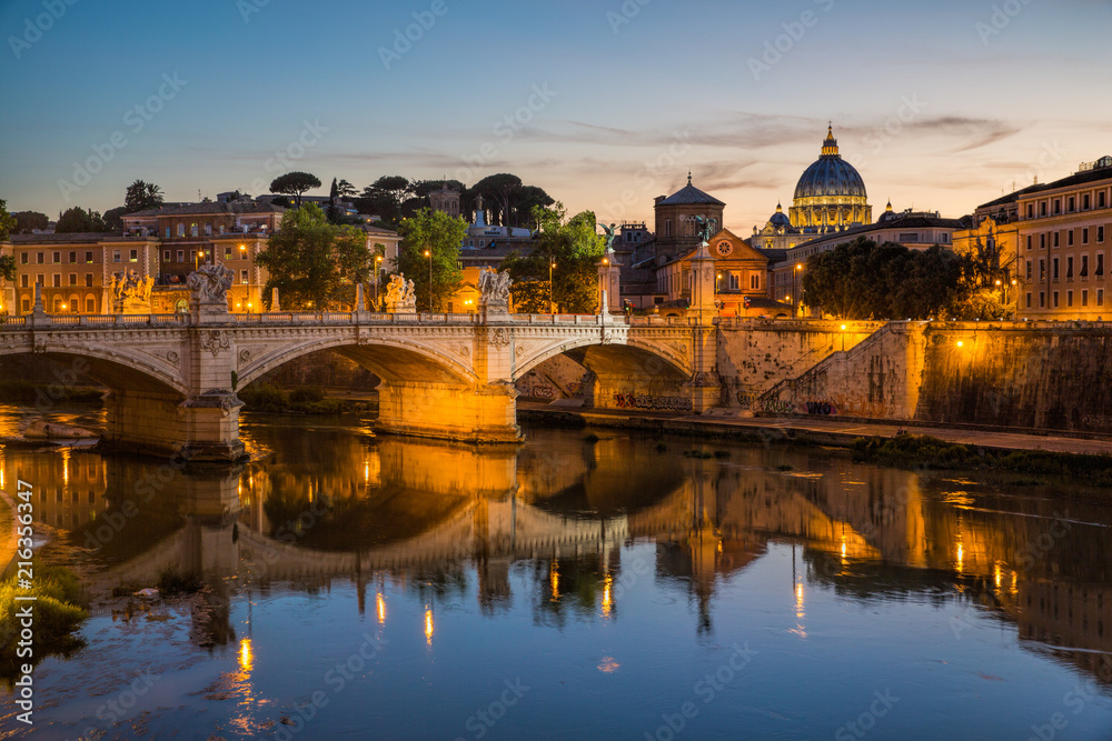 View of St Peter's Cathedral and the Tiber river from Pont Sant'Angelo at dusk