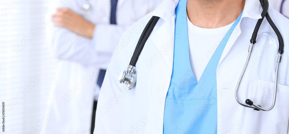Groupe of unknown doctors standing straight in hospital office. Close Up of stethoscope at practitioner breast Groupe of unknown doctors standing straight in hospital office. Close Up of stethoscope at practitioner breast
