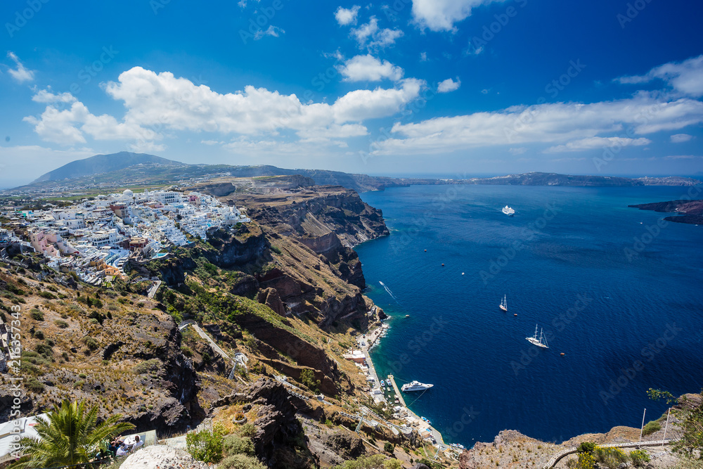 Gorgeous view of Aegean sea from Fira in Santorini, Greece. Cruise ships, boats, the town of Fira the caldera can be seen in the deep blue sea.
