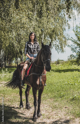 Woman enjoying horse company. Young Beautiful Woman dressed plaid shirt With black Horse Outdoors, stylish girl at american country style  © T.Den_Team