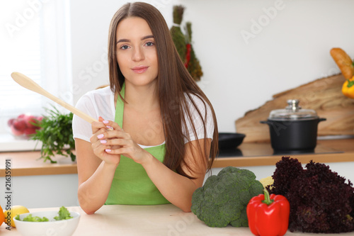 Young woman cooking in kitchen. Householding, tasty food and vegetarian in lifestyle concepts photo