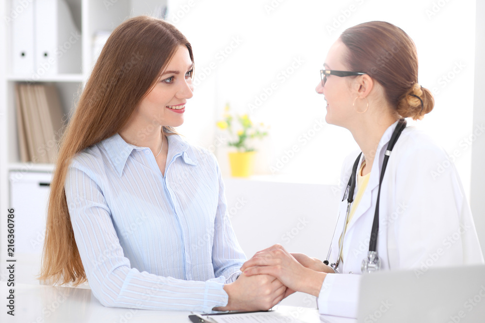 Doctor and patient sitting at the desk near window Doctor and patient sitting at the desk near window