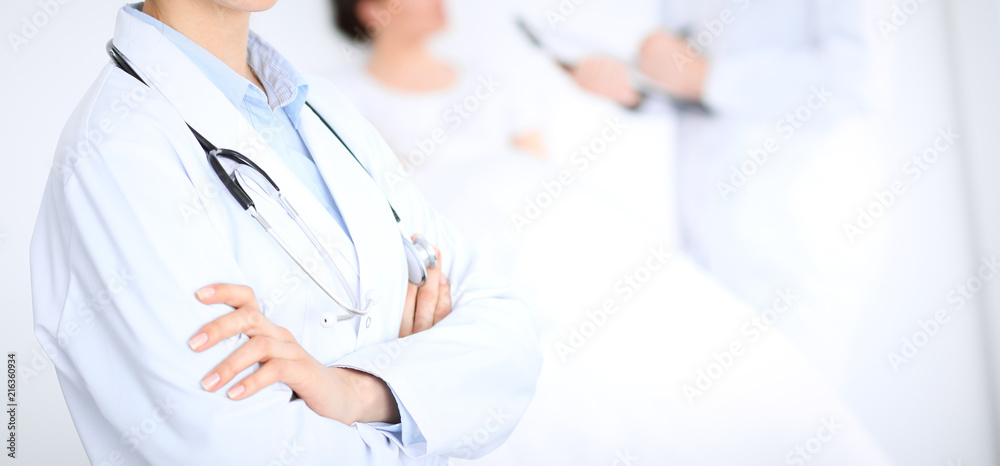 Unknown female doctor with medical staff at hospital. Closeup of stethoscope Unknown female doctor with medical staff at hospital. Closeup of stethoscope