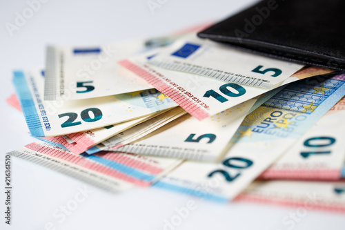 Photos Many euro banknotes in black leather wallet on white background