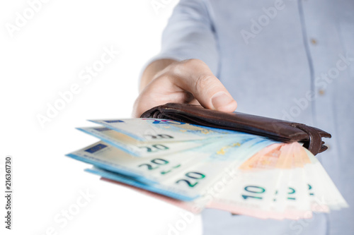 Hand giving a leather purse full of euro banknotes, isolated on white background