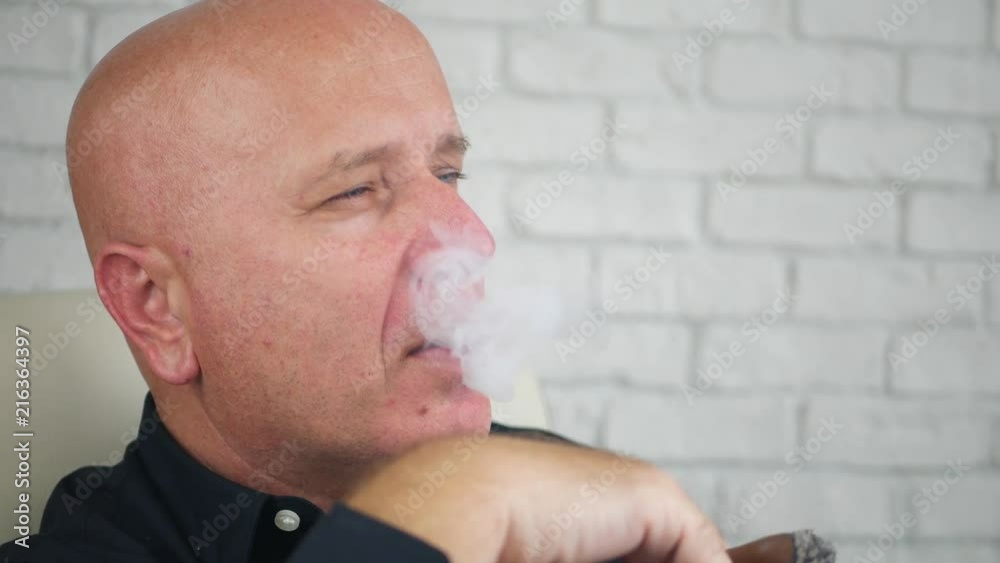 Serious Businessman Image Smoking a Cigar In Office Room Serious Businessman Image Smoking a Cigar In Office Room