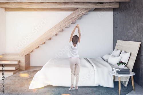 Woman in white and wooden Scandinavian bedroom