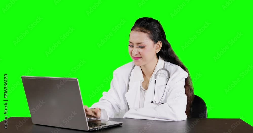 Young female doctor working with a laptop computer while thinking. Shot in 4k resolution with green screen background Young female doctor working with a laptop computer while thinking. Shot in 4k resolution with green screen background