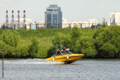Photography Yellow wakeboard boat in Moscow river on the background of green shore and new b