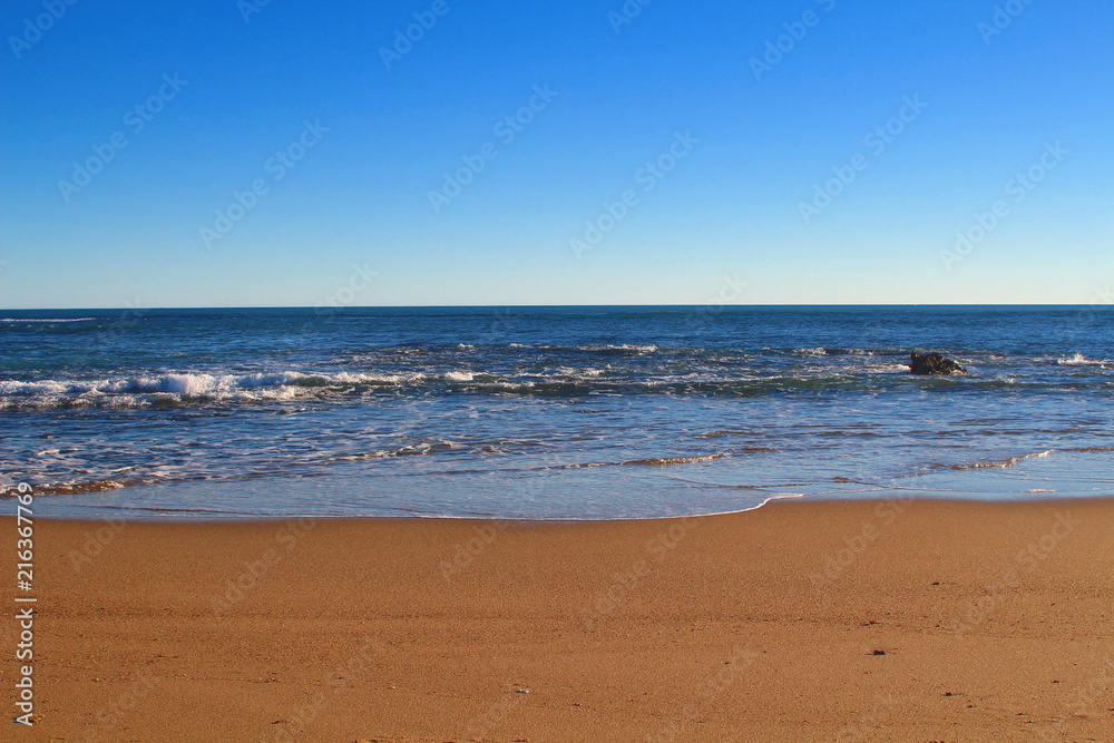 Golden sand beach, blue ocean and sky background - Port Denison, Western Australia